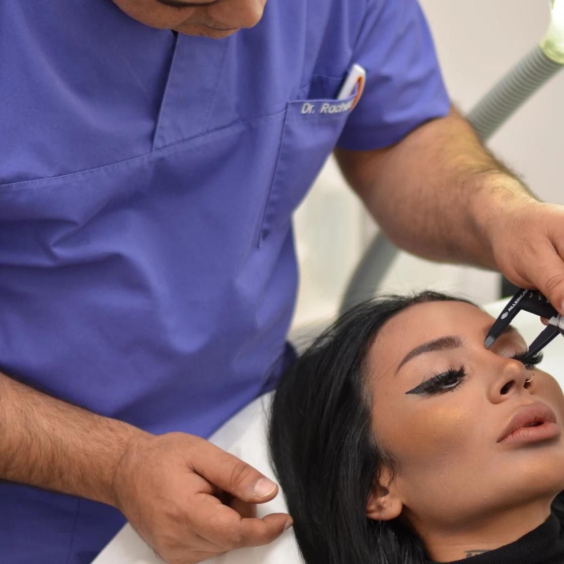 Dr. Rachad măsoară pleoapa unei paciente, la consultația pentru blefaroplastie