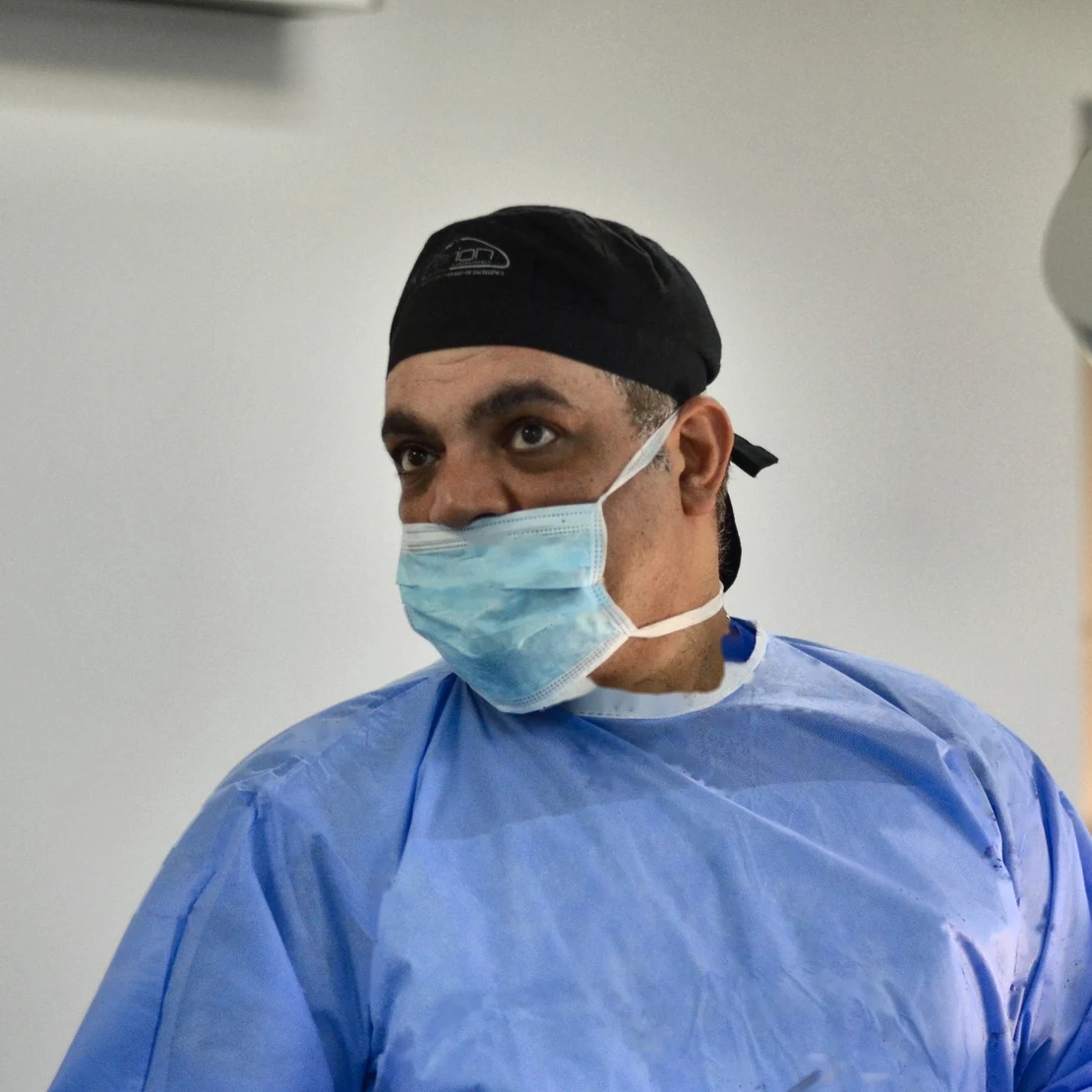 Dr. Rachad, în halat și mască, în sala de operație