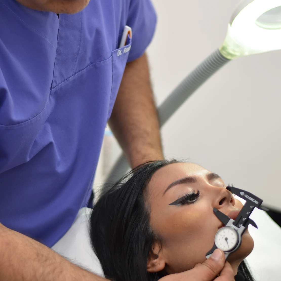 Dr. Rachad măsoară nasul unei paciente, la consultația pentru rinoplastie