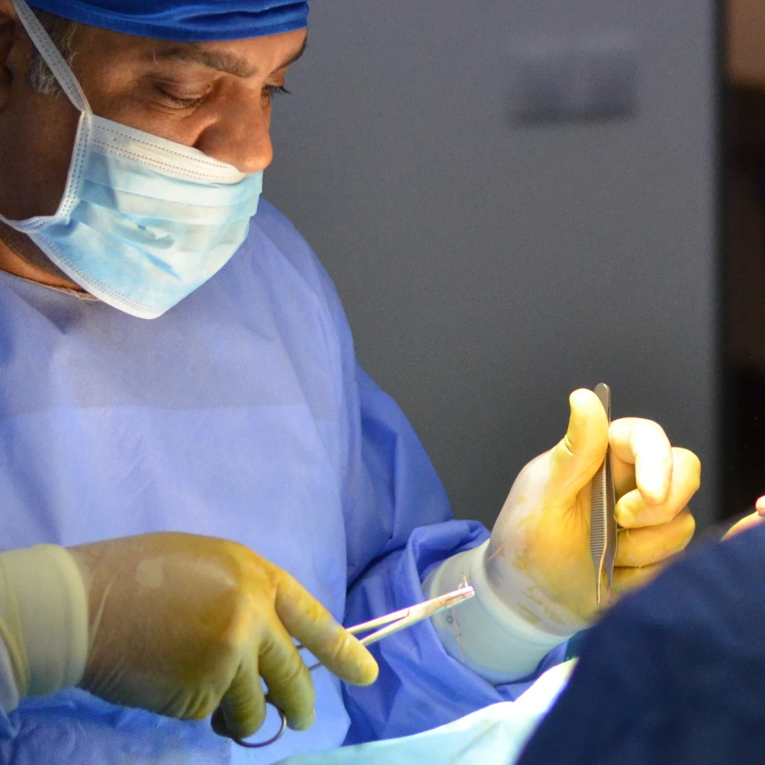 Chirurgul, în timpul unei liposucții, în sala de operație