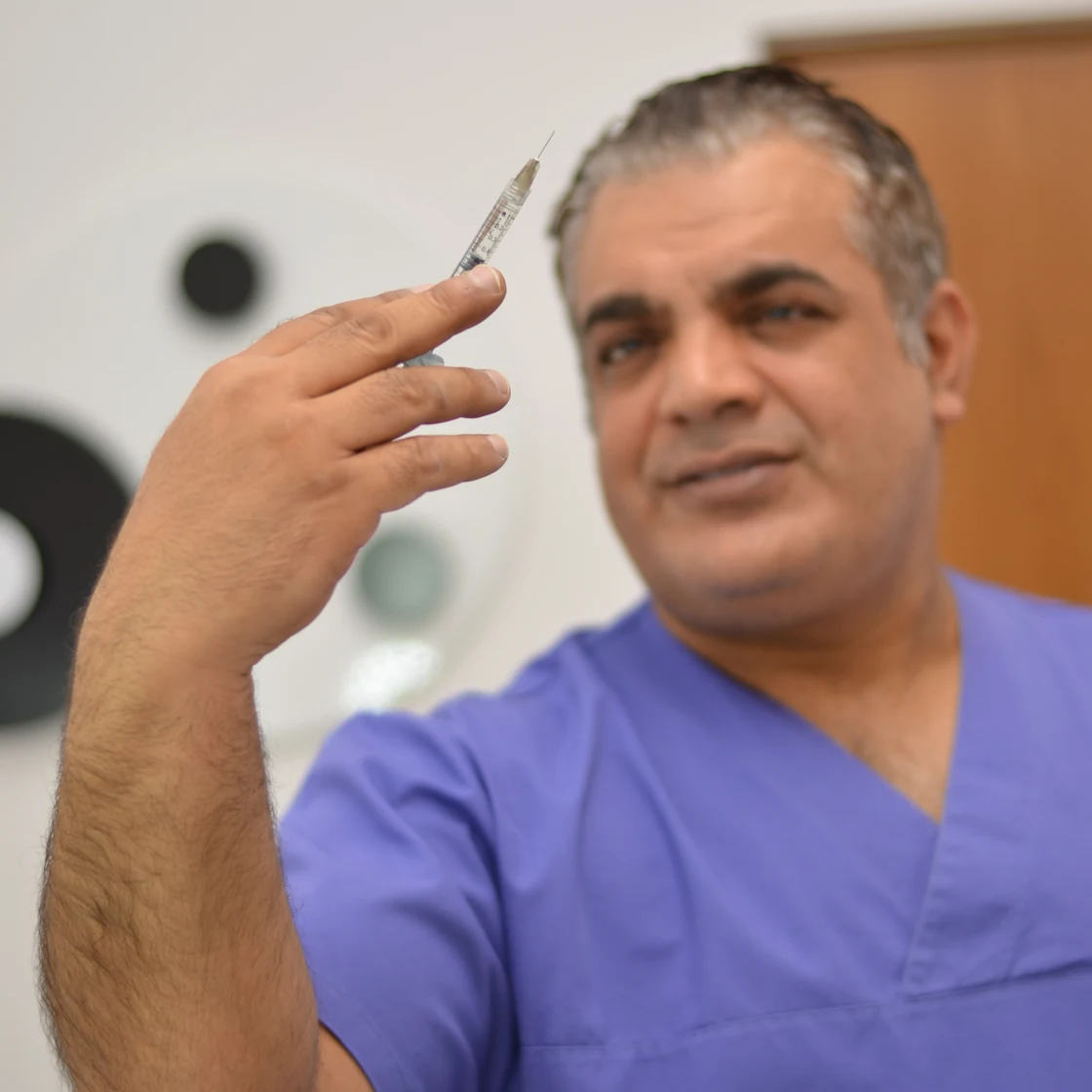 Dr. Rachad ține bisturiul, în pregătirea unei operații de reducție mamară